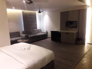 a hotel room with a bed and a couch at Hotel The Legend in Kānpur