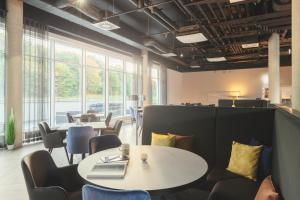 a room with tables and chairs and windows at Select Hotel Augsburg in Neusäß