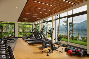 un gimnasio con una fila de cintas de correr y máquinas elípticas en Taj Wayanad Resort & Spa, Kerala, en Wayanad