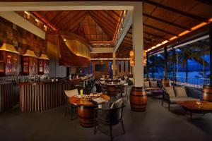 a restaurant with tables and chairs and a bar at Taj Wayanad Resort & Spa, Kerala in Wayanad