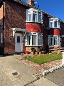 a red brick house with a white door at Fionn House Darlington in Darlington