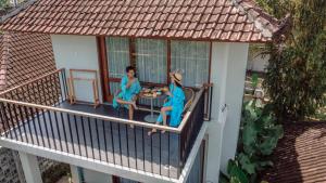 two women sitting on the balcony of a house at Ecozy Dijiwa Canggu in Canggu