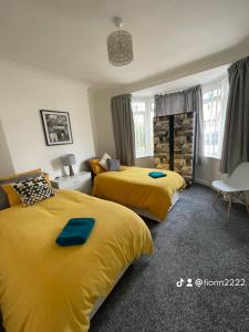 duas camas num quarto de hotel com camas amarelas em Fionn House Darlington em Darlington