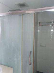 La salle de bains est pourvue d'une douche avec une porte en verre. dans l'établissement Mg Suite 1bedroom Apartment by Just Inn Management, à Semarang