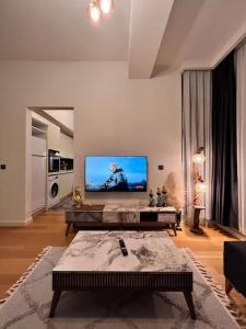 sala de estar con TV de pantalla grande en la pared en Mükemmel konumda şehir manzaralı ve balkonlu daire, en Estambul