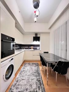 cocina con mesa y lavadora en Mükemmel konumda şehir manzaralı ve balkonlu daire, en Estambul