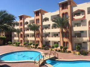 an apartment complex with a swimming pool and palm trees at Viva Reef Fully Furnished Suite in Sharm El Sheikh
