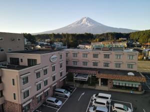 富士吉田的住宿－富士吉田西旅館，城市的空中景观,背景是高山