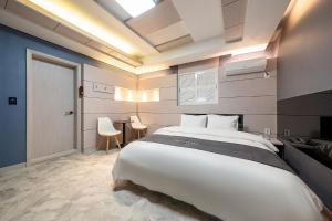 a bedroom with a large bed and a table at The Nox Hotel in Suwon