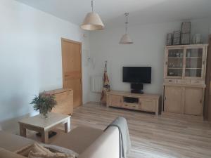 a living room with a couch and a tv at THE HOME Hervás Plaza de garaje gratis in Hervás