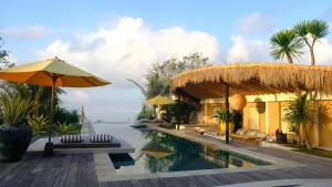 ein Resort mit einem Pool und einem Sonnenschirm in der Unterkunft Katoni Villa Lembongan in Nusa Lembongan