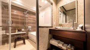 a bathroom with a sink and a tub and a shower at Hiroshima Grand Intelligent Hotel in Hiroshima