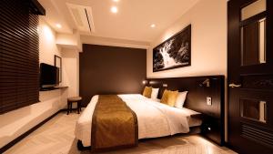 1 dormitorio con 1 cama y TV de pantalla plana en Hiroshima Grand Intelligent Hotel en Hiroshima