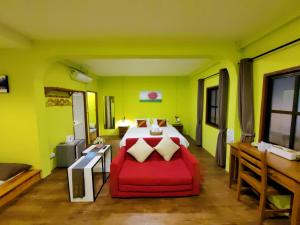 a bedroom with a bed and a red couch at Chiang Mai Gate house in Chiang Mai