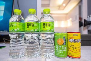 três garrafas de água e duas latas de sumo de laranja em The Nox Hotel em Suwon