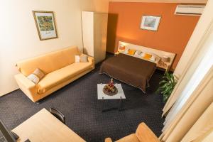 Hotel Pacific في تيميشوارا: غرفة في الفندق مع أريكة وسرير