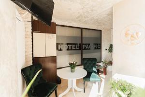 Hotel Pacific في تيميشوارا: غرفة طعام مع طاولة وكراسي خضراء