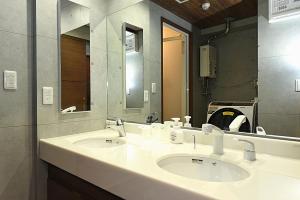 a bathroom with two sinks and a large mirror at Hills Garden 本通 in Tsukisappu