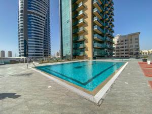 a swimming pool on the roof of a building with tall buildings at Urban Studio at The Square Tower Jumeirah Village Circle by Deluxe Holiday Homes in Dubai