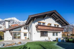 a white house with a wooden roof at Landhaus Plainer in Innsbruck