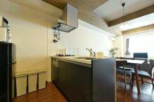 uma cozinha com um lavatório e uma mesa com cadeiras em Hills Garden 本通 em Tsukisappu