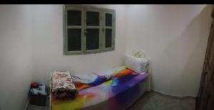 a bedroom with a rainbow bed and a window at غرفة فردية خاصة للاناث in Bel Aroussi