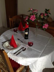 a table with red napkins and a bottle of wine and flowers at Apartments Sevo in Trogir