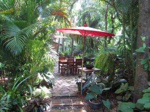 une terrasse avec une table, des chaises et un parasol dans l'établissement Happiness Resort Sukhothai, à Sukhothaï