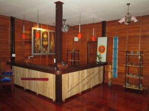 eine Bar in einem Zimmer mit holzgetäfelten Wänden in der Unterkunft Happiness Resort Sukhothai in Sukhothai