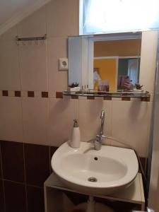 ハイドゥソボスローにあるAranyeső Apartmanのバスルーム(白い洗面台、鏡付)