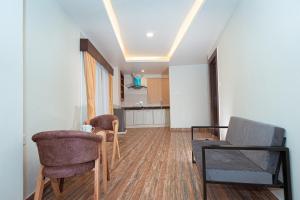 a living room with chairs and a table and a kitchen at POMs Penthouse in Pokhara +17 photos