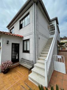 Biały dom z ławką na patio w obiekcie Apartamento con piscina privada w mieście Vigo