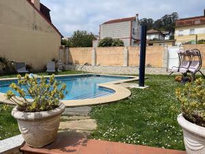 een klein zwembad in een tuin met twee planten bij Apartamento con piscina privada in Vigo