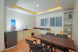 a kitchen with a wooden table and chairs at POMs Penthouse in Pokhara