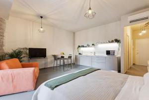 ein Schlafzimmer mit einem Bett und eine Küche mit einem Sofa in der Unterkunft Etna Suite Design Apartments in Catania