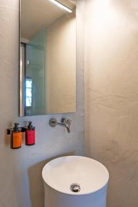 a bathroom with a white sink and a mirror at Maris Lindos Suites & Apartments in Lindos