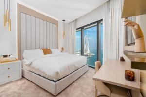 a bedroom with a bed and a desk and a window at Lux BnB I The Address JBR I Ocean View in Dubai