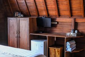 Habitación con escritorio, TV y cama. en You and We House, en Nusa Penida