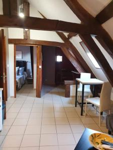 ein Wohnzimmer mit einem Bett und einem Esszimmer in der Unterkunft La Mansarde: appartement tout confort à Vatan in Vatan