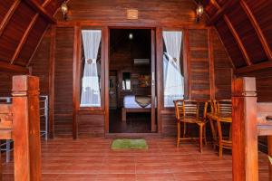 Habitación de madera con mesa, sillas y 1 dormitorio en You and We House en Nusa Penida