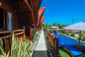 un resort con piscina con panchine e ombrellone di You and We House a Nusa Penida