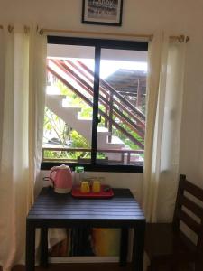 a table with a tea pot on it in front of a window at MLB Beachfront Apartment in Siquijor
