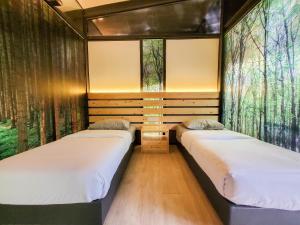 two beds in a room with trees on the wall at X Park Iskandar Puteri in Nusajaya