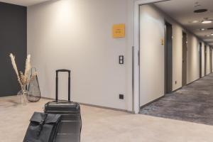 アウクスブルクにあるCandlewood Suites Augsburg by IHGの廊下の床に置かれたスーツケース