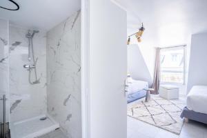 パリにある145 - Urban Pretty Studio in Center of Parisの白いバスルーム(シャワー付)、ベッドルーム1室が備わります。