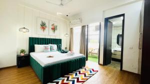 a bedroom with a bed with a green headboard at Olive Service Apartments - City Centre Noida in Noida