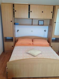 Apartments Sevo في تروغير: سرير في غرفة مع دواليب خشبية