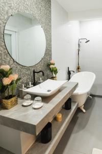ein Badezimmer mit einem großen Spiegel und einem Waschbecken in der Unterkunft Monica Midtown Suites in General Santos