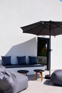 un soggiorno con divano e ombrellone di Elies Aesthetic Living a Iraklitsa