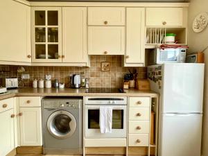 a kitchen with white cabinets and a washing machine at Cosy boutique apartment in colourful Bristol in Bristol